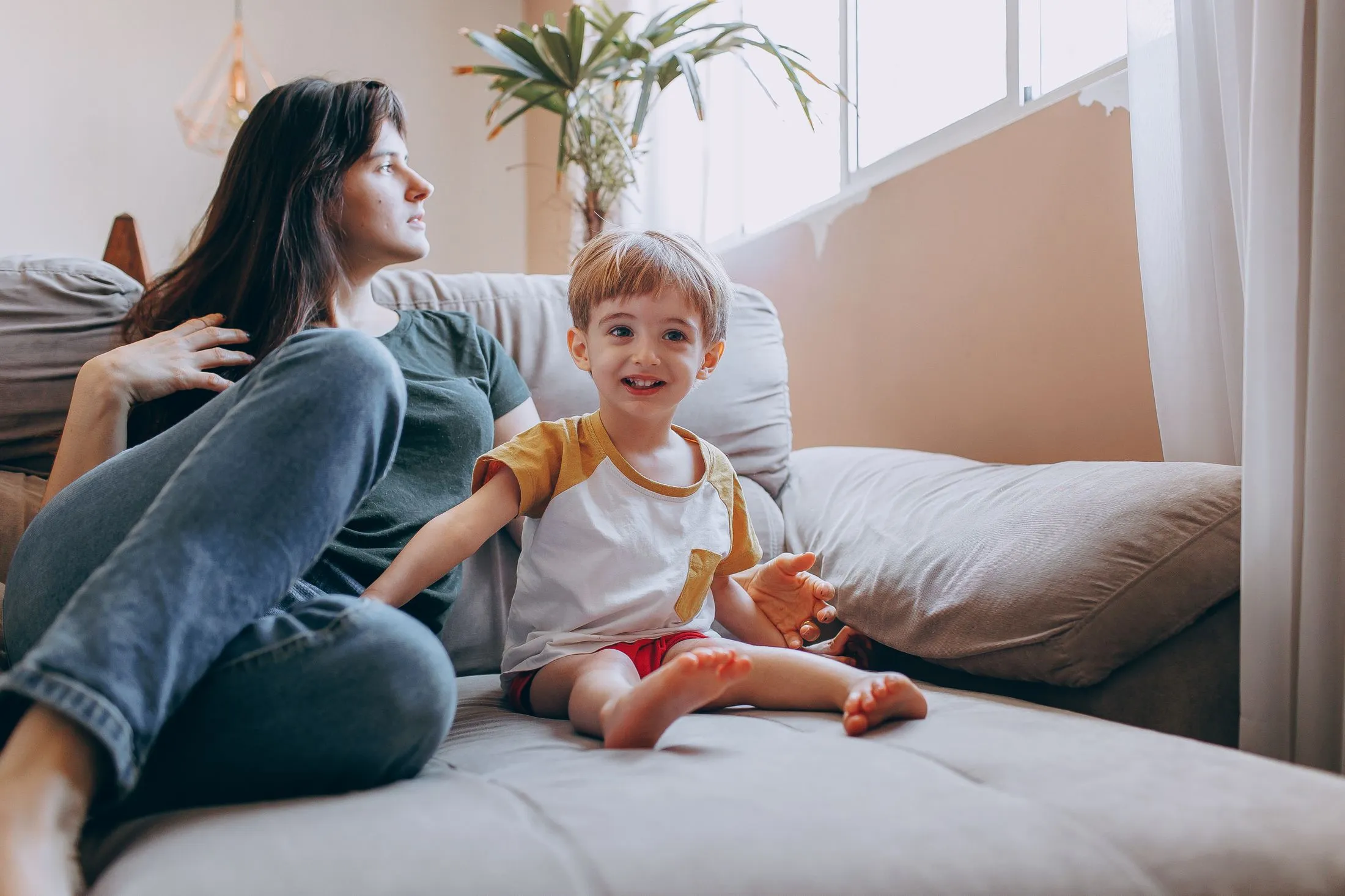 Parent and child relaxing on a sofa at home