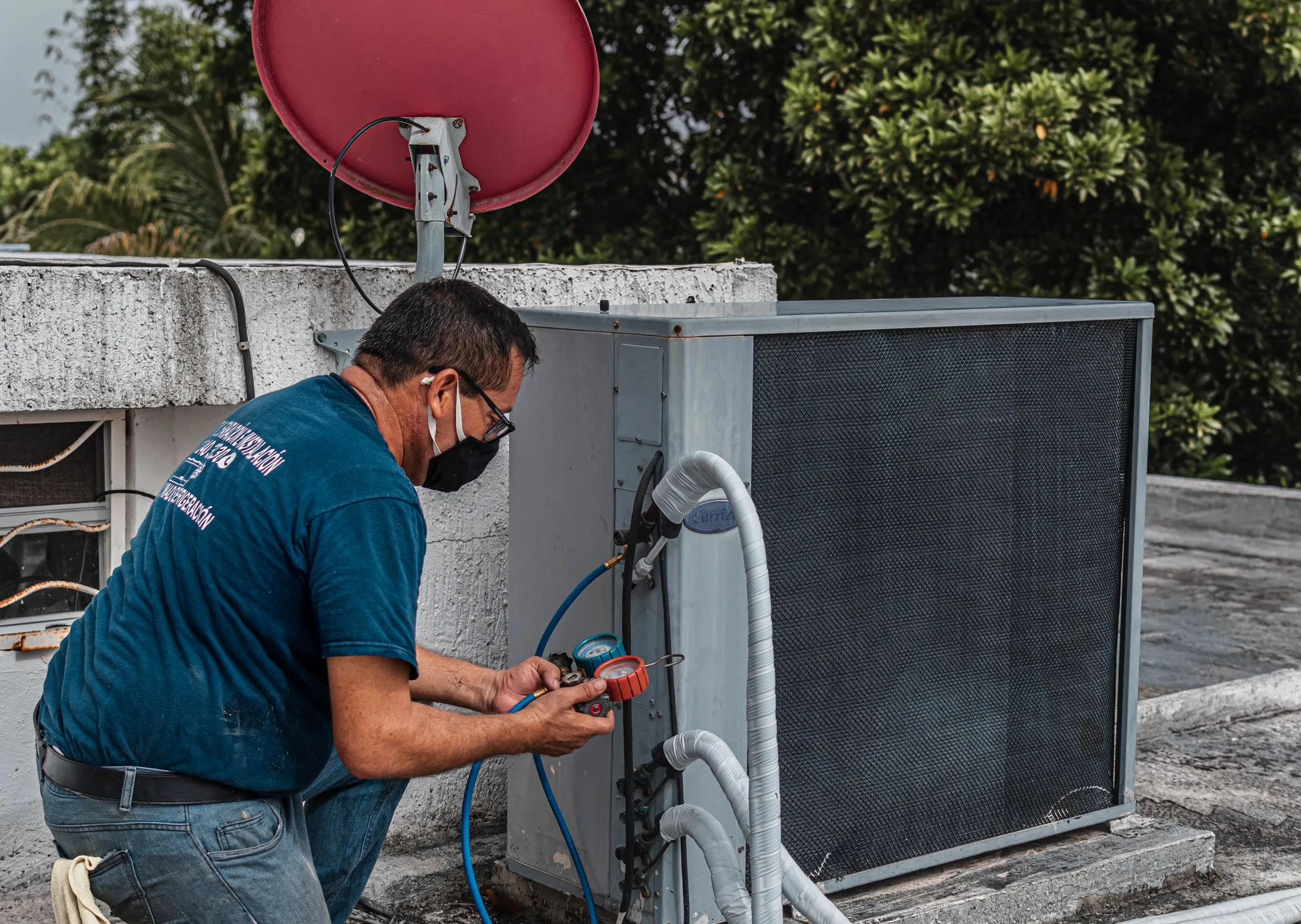 Technician servicing a rooftop condenser