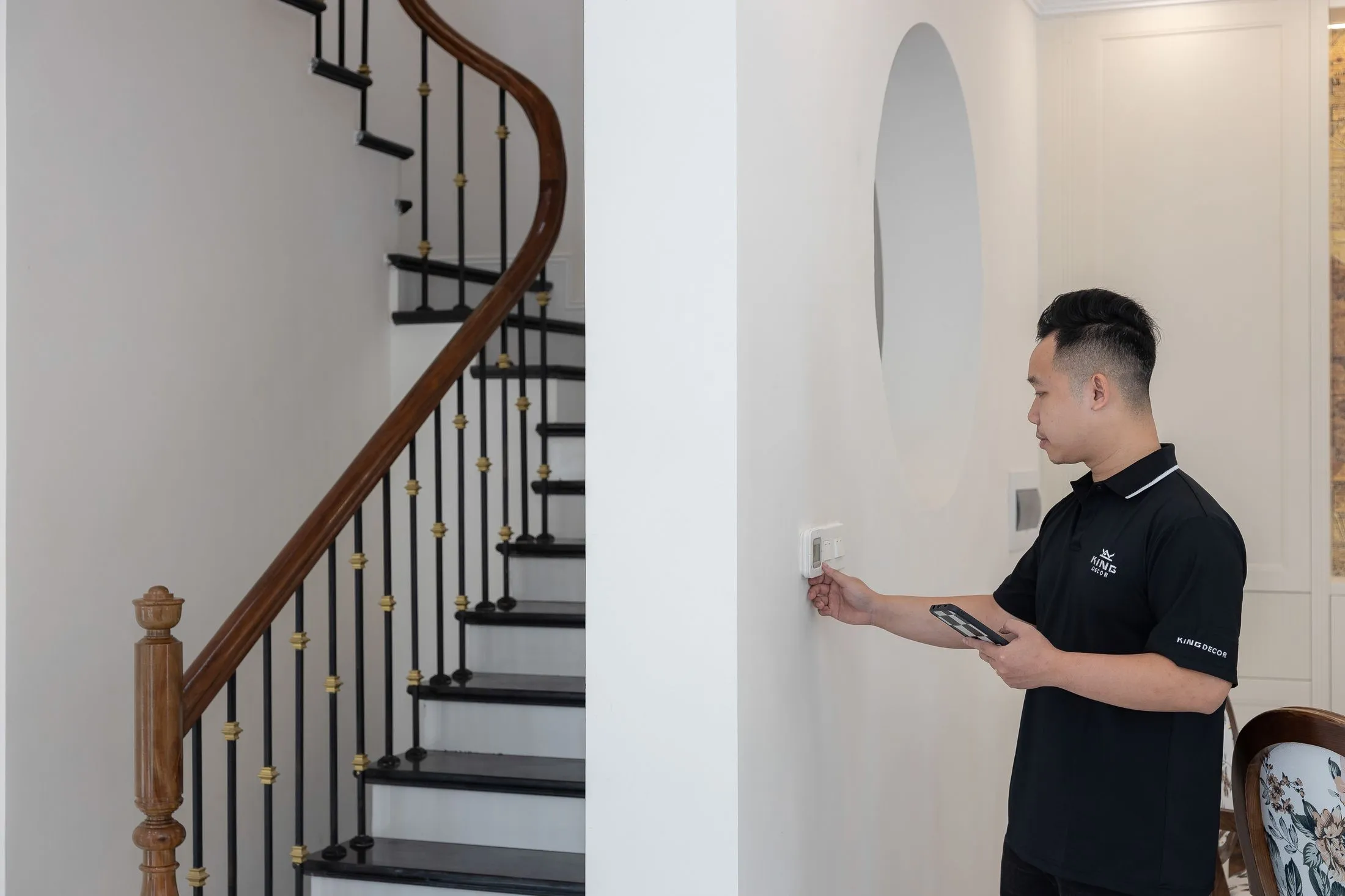 Technician checking a wall thermostat with a tablet